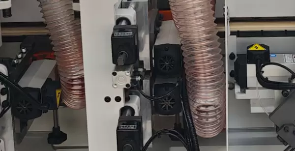<b>Flat and rough trimming mechanism</b><br/>Trim the excess edge banding protruding from the upper and lower surfaces of the wood board, ensuring that the upper and lower edges of the edge banding align flush with the upper and lower surfaces of the wood board.